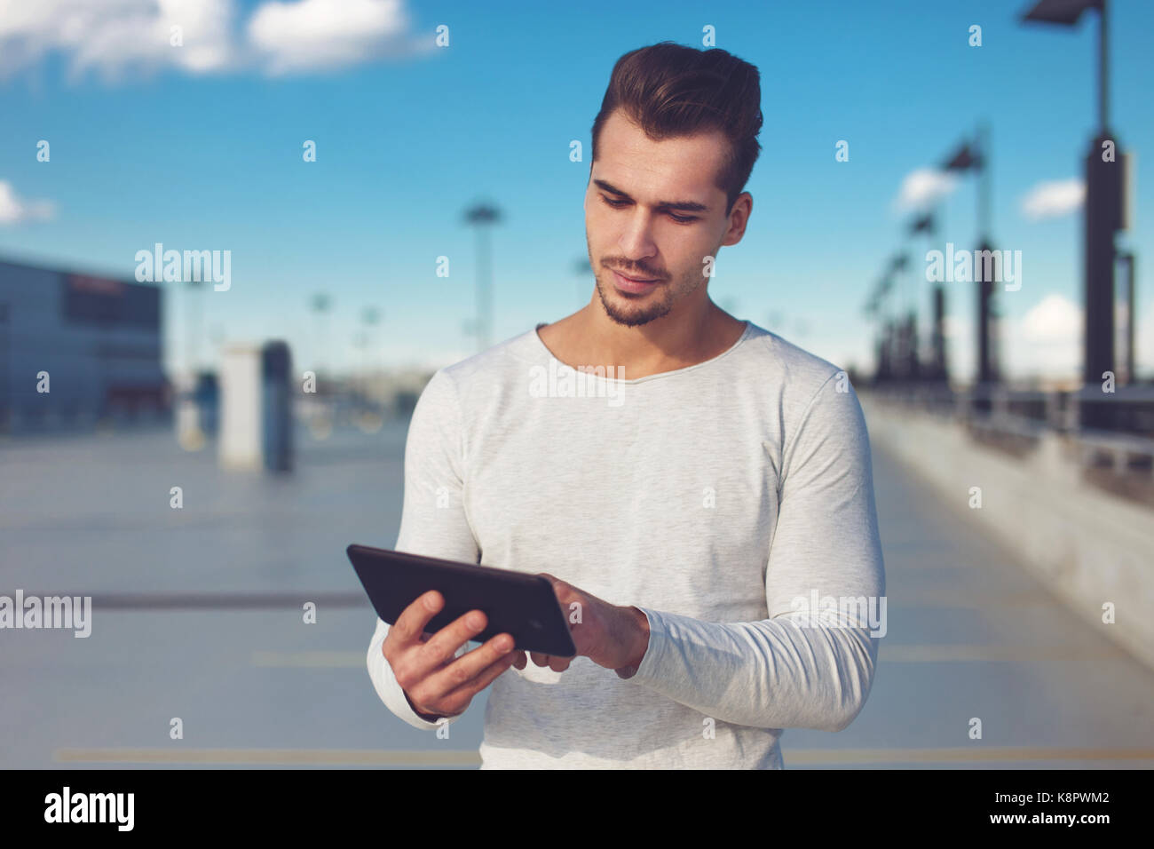 Junge legerer Mann mit digitalen tablet Outdoor, großer Raum Stockfoto