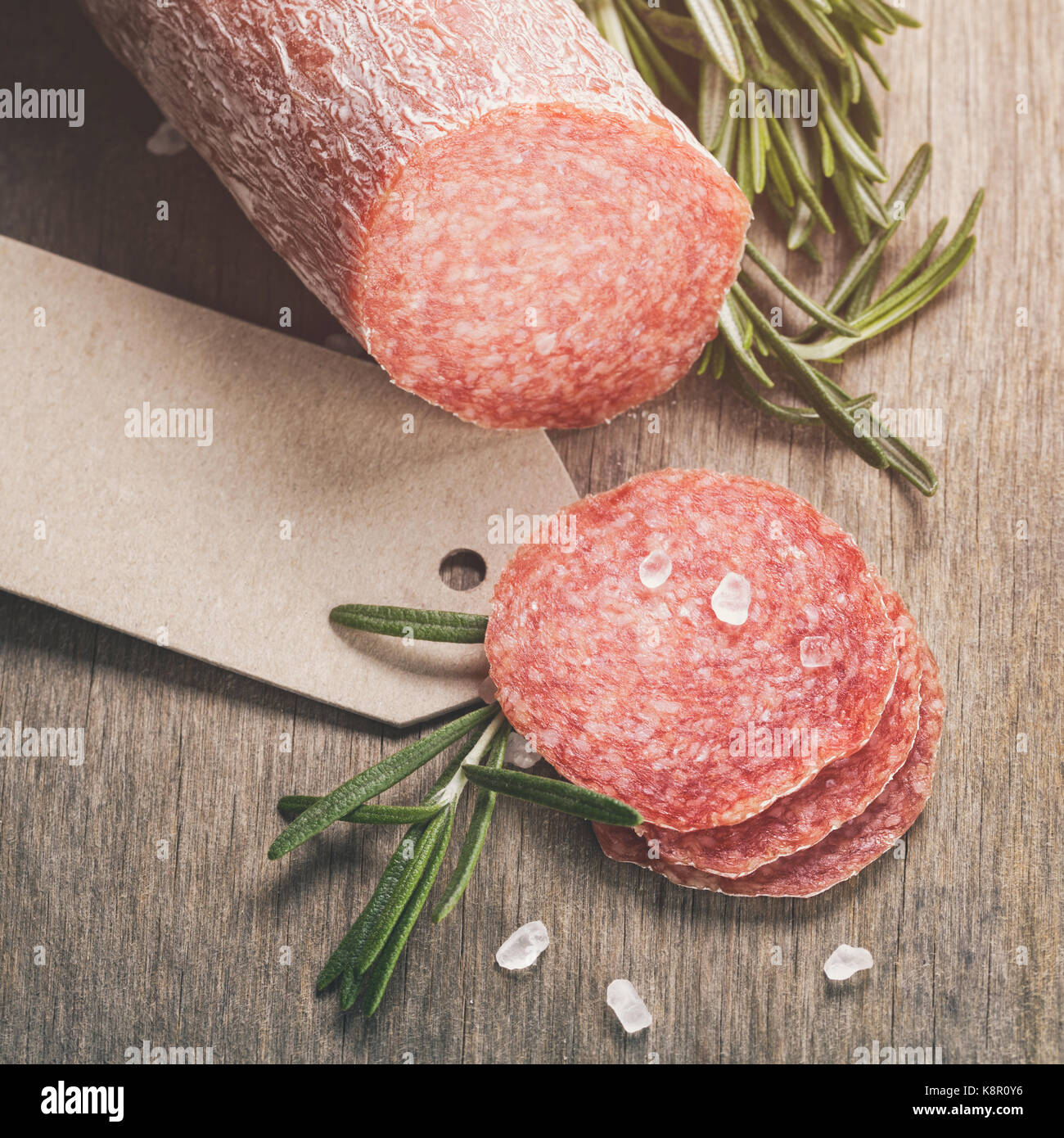 Italienische Salami Wurstscheiben mit Rosmarin und Meersalz Stockfoto