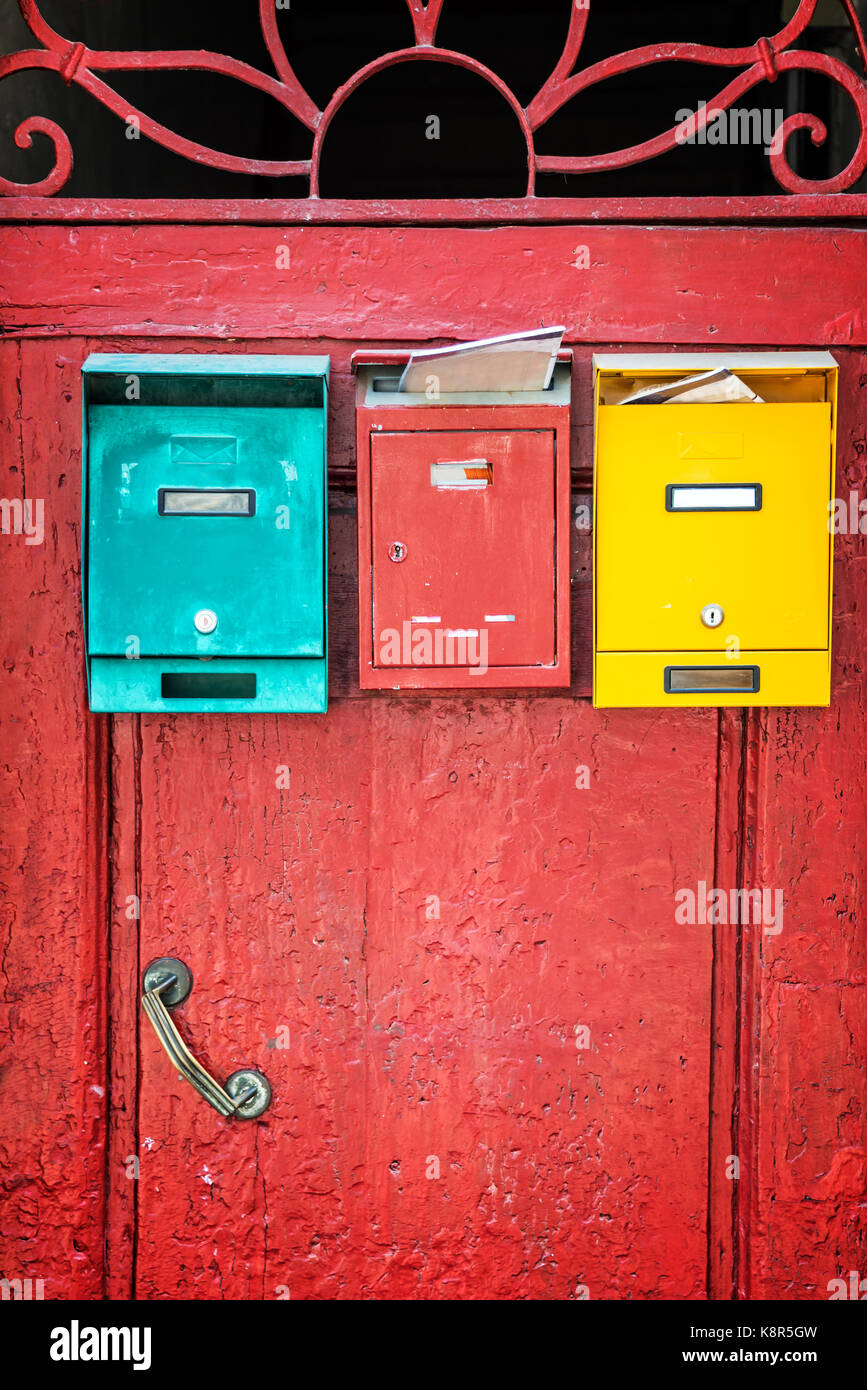 Rote Holztür mit bunten Mailboxen, Florenz, Italien Stockfoto
