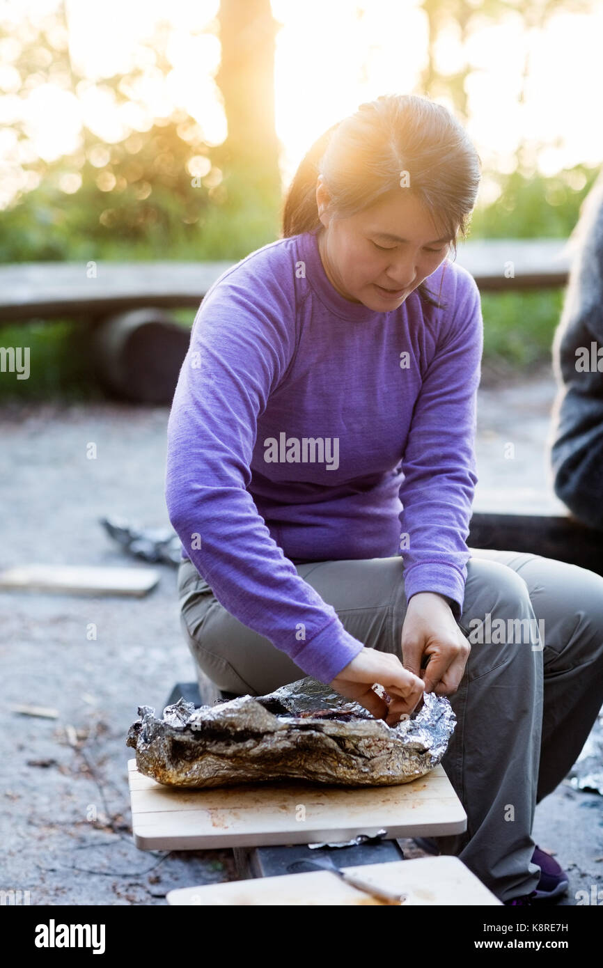 Geschäftsfrau, Essen sie In der Folie beim Sitzen auf der Werkbank Stockfoto