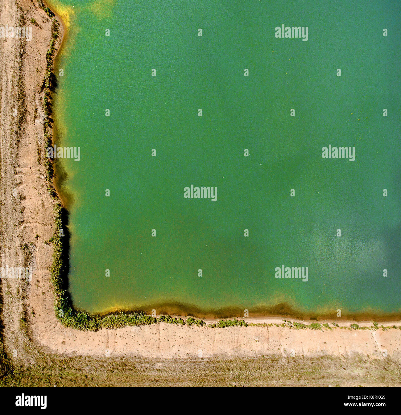 Ecke einer Kiesgrube, abstrakte Wirkung, die durch senkrechte Aufzeichnung mit der Drohne, als Hintergrund mit freier Speicherplatz, Luftaufnahme von grünem Wasser Stockfoto
