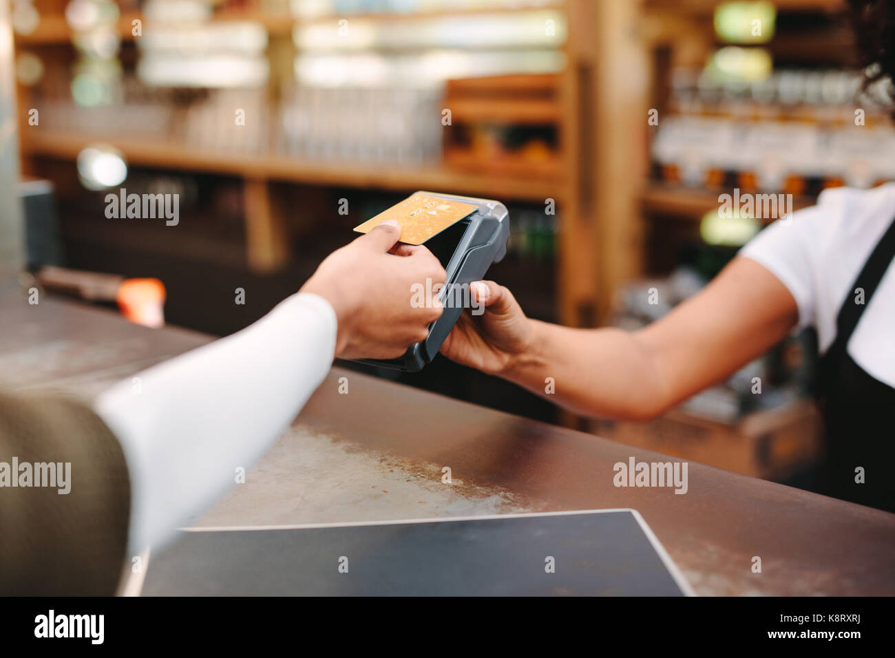 Kunden drahtlose oder kontaktlose Zahlung mit Kreditkarte. Store Arbeitnehmer akzeptieren Zahlung über NFC-Technologie. Stockfoto