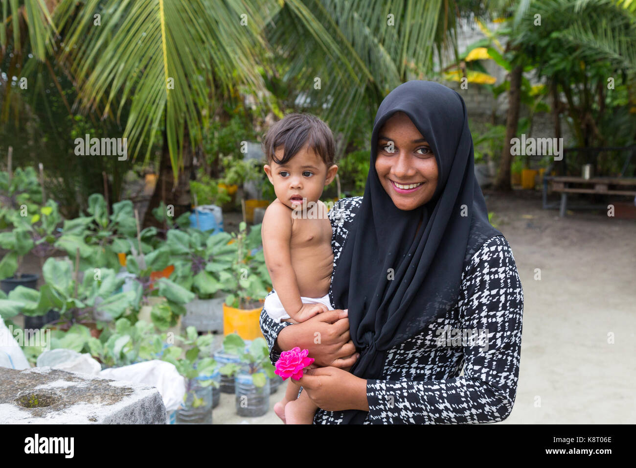 Malediven - Ein junger Malediven asiatischen muslimische Frau, die ein Kind, Rasdhoo Village, Malediven, Asien Stockfoto