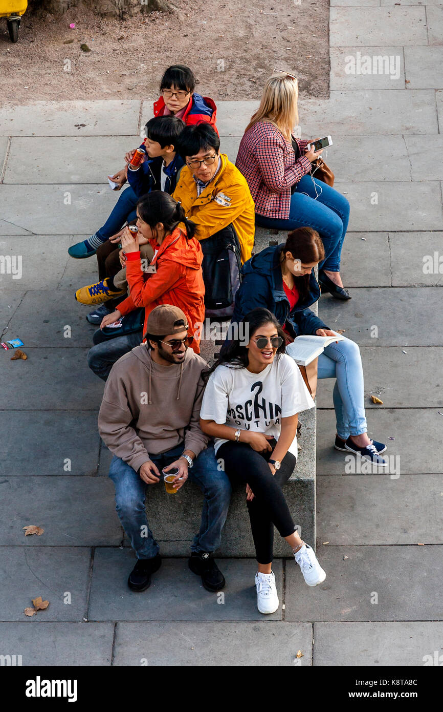 Eine Gruppe von Touristen auf einer Bank sitzen, die Southbank, London, UK Stockfoto