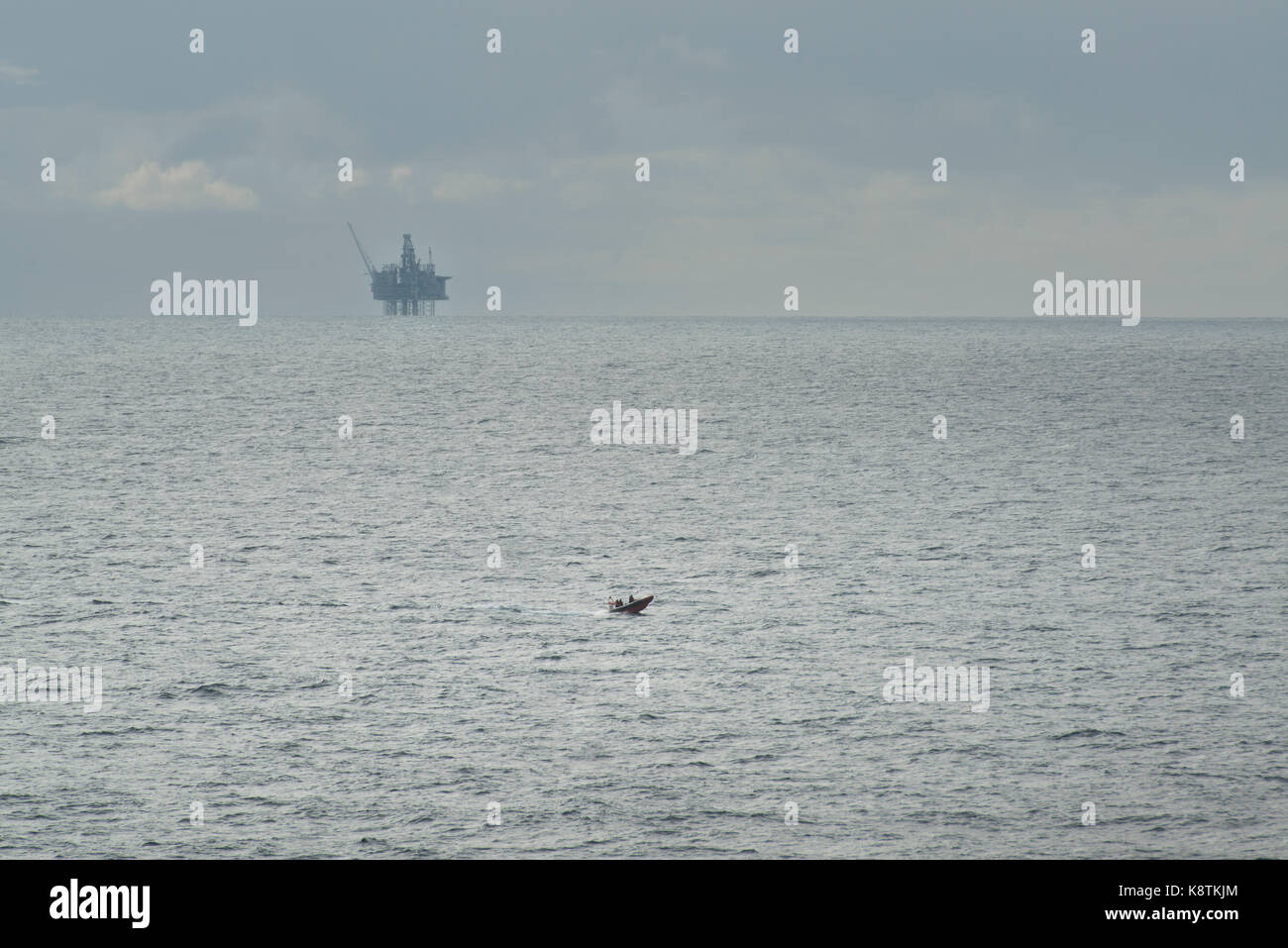 RNLI leben Boot, rettungsfahrzeug Segeln in der Nordsee, mit Öl und Gas rig in der Ferne. Credit: LEE RAMSDEN/ALAMY Stockfoto