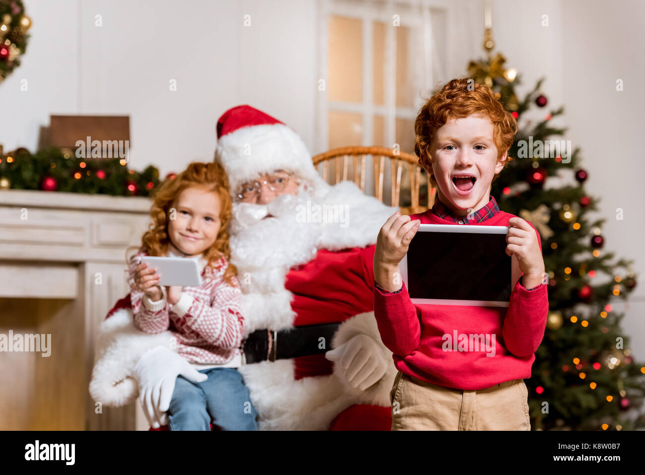 Santa Claus und Kinder mit digitalen Geräten Stockfoto