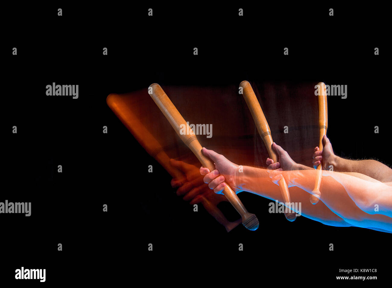 Den Arm mit einem Baseballschläger auf schwarzem Hintergrund Stockfoto