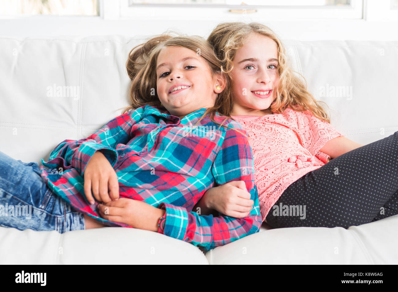 Glückliche kleine Mädchen lag auf Sofa Stockfoto