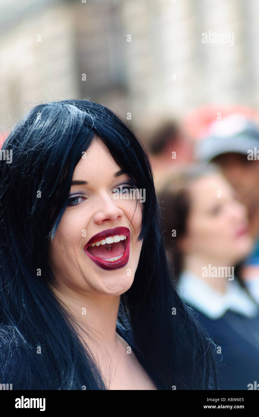 Interpret gekleidet wie Morticia der Addams Family auf der Royal Mile während des Edinburgh International Fringe Festival, Schottland, Großbritannien Stockfoto