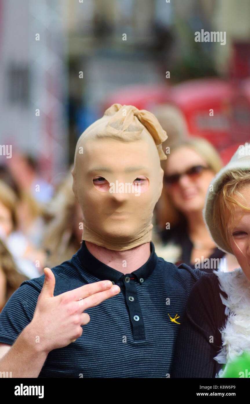 Mann mit Strumpf über Kopf und Hand wie eine Pistole auf der Royal Mile während des Edinburgh International Fringe Festival, Schottland, UK gebildet Stockfoto
