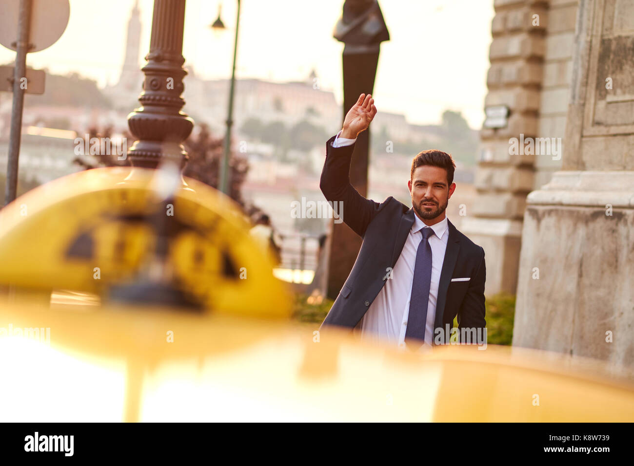 Ein hübscher junger Geschäftsmann winken ein Taxi Stockfoto