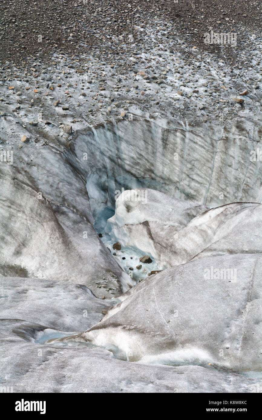 Schmelzende Gletscher Wasser rauscht unten einen Kanal aus und verschwindet um die Ecke. Stockfoto