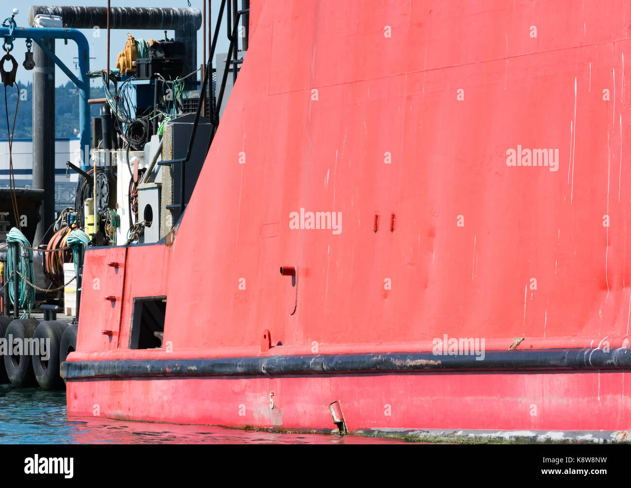 Die hohe Seite des einen Bootsrumpf fängt die Sonne und die rote Farbe erstrahlt. Stockfoto