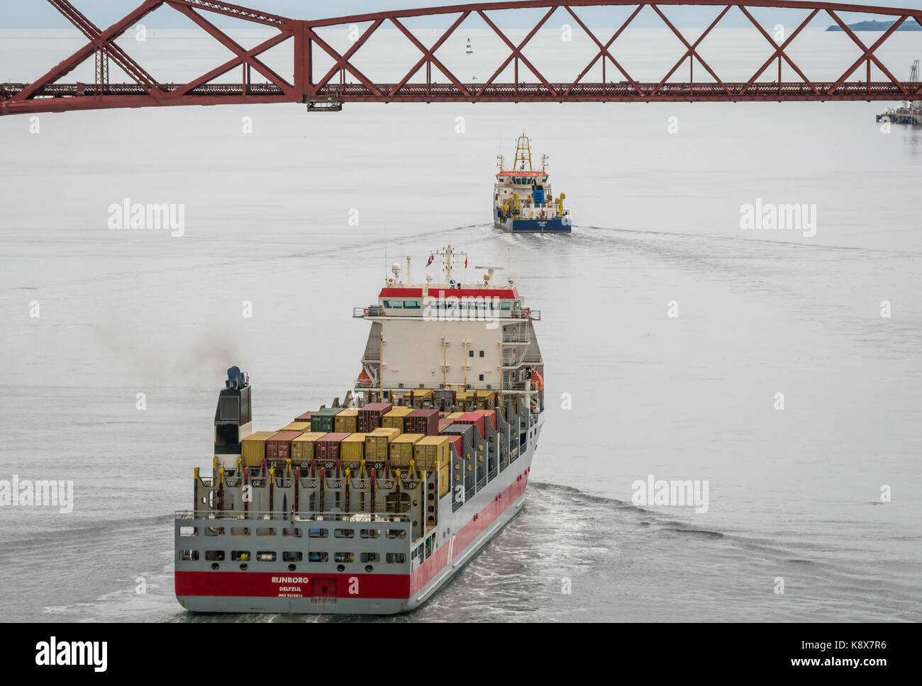 Containerschiff Rijnborg, aus den Niederlanden mit Cargo segeln in Richtung Ausleger Forth Rail Bridge, Schottland, Großbritannien, mit ukd Orca Suction Hopper Stockfoto