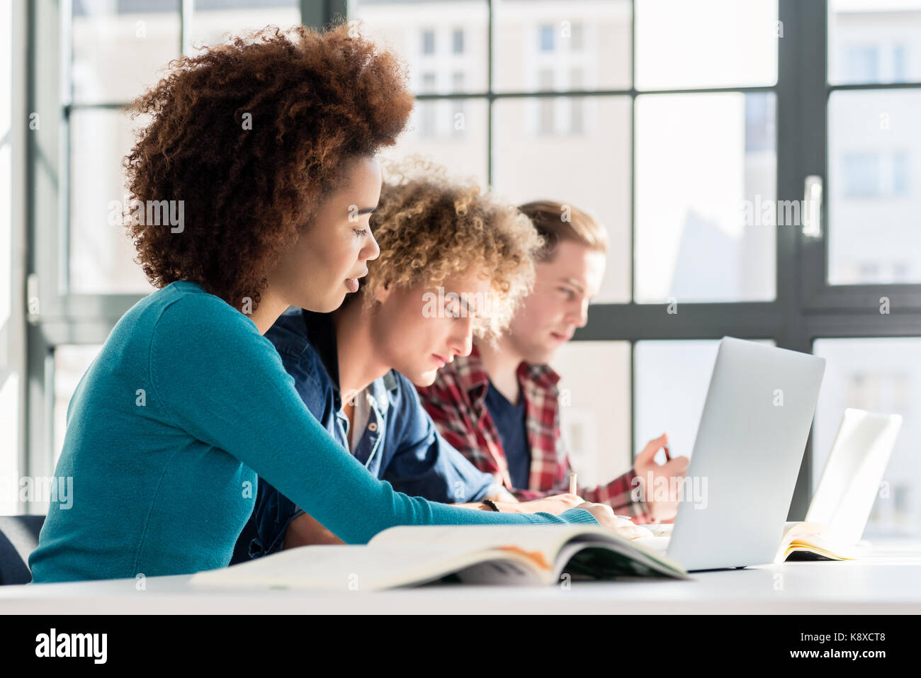 Student lächelnd, während Sie einen Laptop für On-line-Informationen oder v Stockfoto