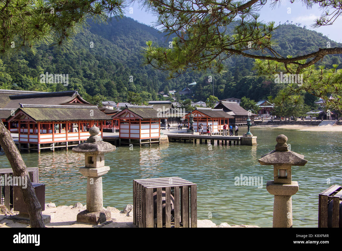 Der Itsukushima-Schrein auf der Insel Miyajima in Japan mit dem Meer und den Hügeln im Hintergrund. Stockfoto