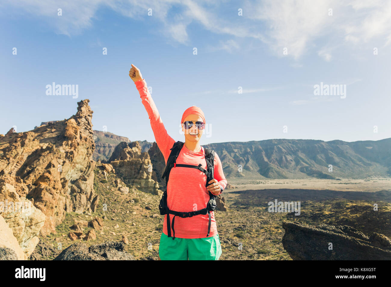 Frau Wanderer mit ausgestreckten Armen in den Bergen. Schönheit Läuferin, Hände hoch und inspirierende Landschaft auf Rocky Trail Wanderweg auf Teneriffa genießen. Stockfoto