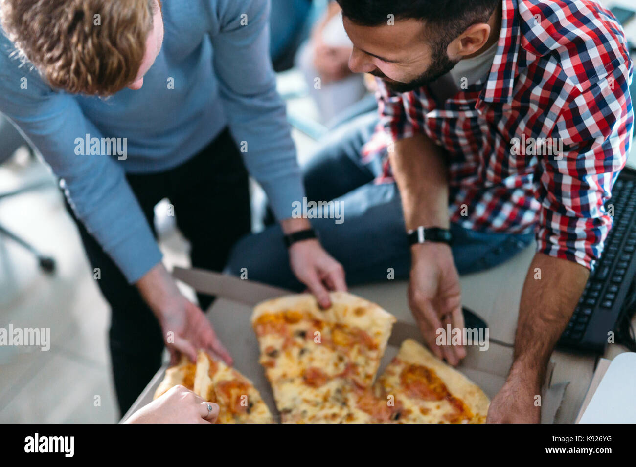 Software enginneers sharing Pizza in der Pause von der Arbeit Stockfoto