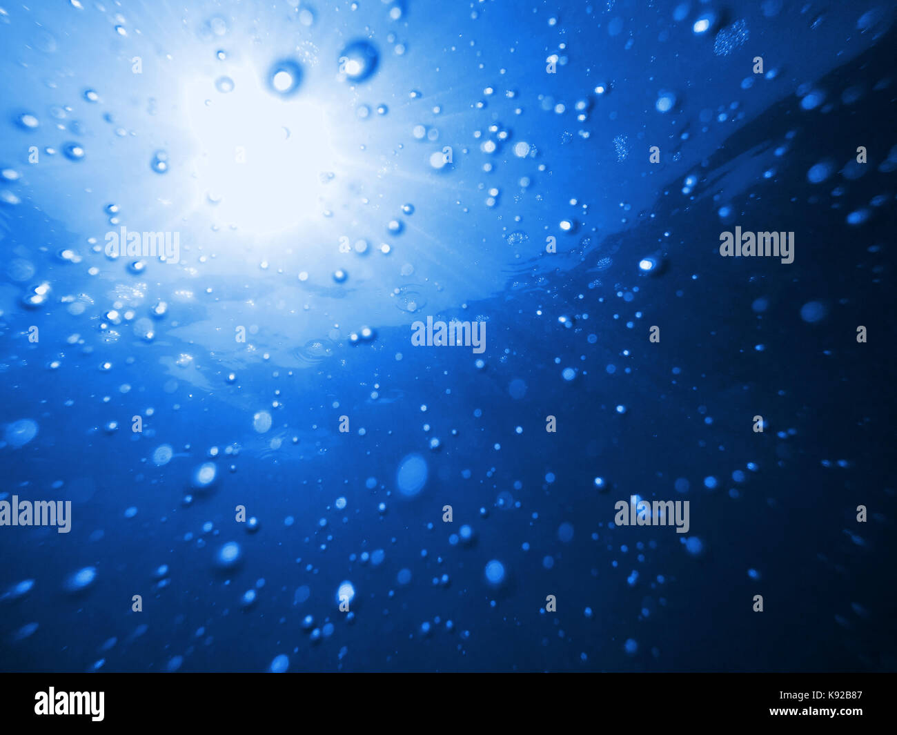 Luftblasen im Wasser und Sonnenlicht Unterwasser, abstrakten Hintergrund Stockfoto