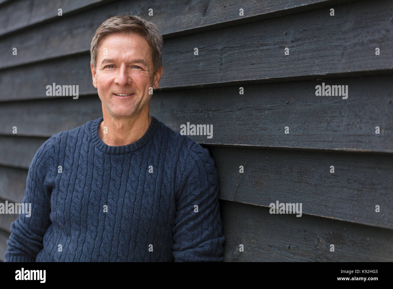 Portraitfotos eines attraktiven, erfolgreich und glücklich lächelnde Menschen als Mann mittleren Alters außerhalb trägt einen blauen Pullover Stockfoto