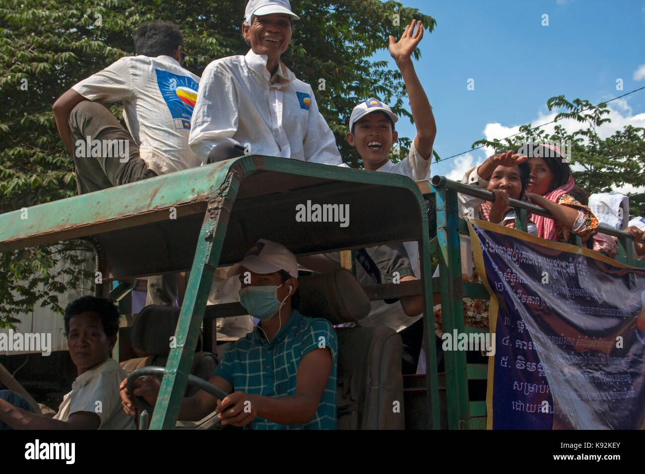 Die Menschen sind Reiten in einem Lkw bei gleichzeitiger Unterstützung der Opposition CNRP Party bei Rallye in Chork Dorf, Tboung Khmum Provinz in Kambodscha. Stockfoto