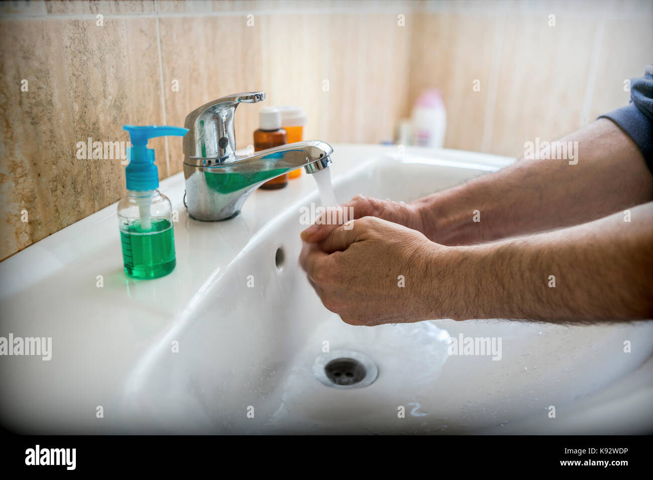 Nahaufnahme eines jungen kaukasischen Mann seine Hände waschen mit Seife im Waschbecken der Badezimmer Stockfoto