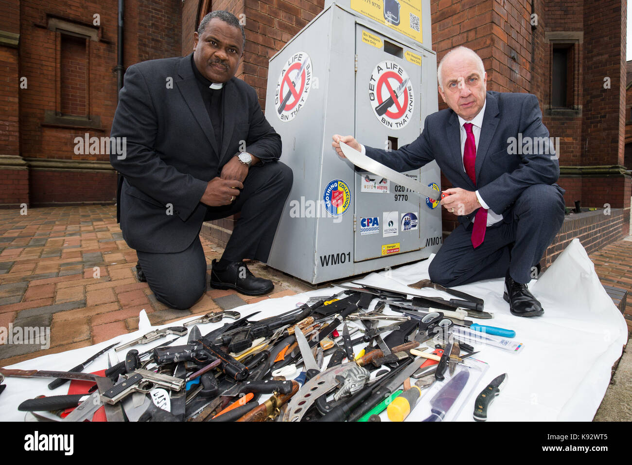 Reverend Bryan Scott (links) von der Cannon Street Baptist Church, Birmingham, West Midlands Polizei und Verbrechen Kommissar David Jamieson, mit Anzeige der neuesten Waffen, die aus der Region Messer Kapitulation Mülltonnen geleert wurden. Stockfoto