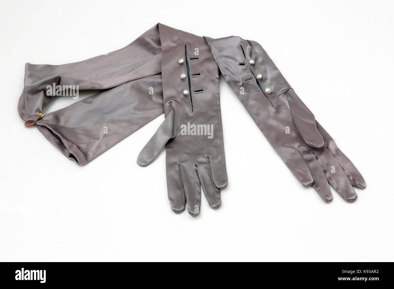Ein paar Vintage lange graue Satin Abend Handschuhe mit Tasten Stockfoto