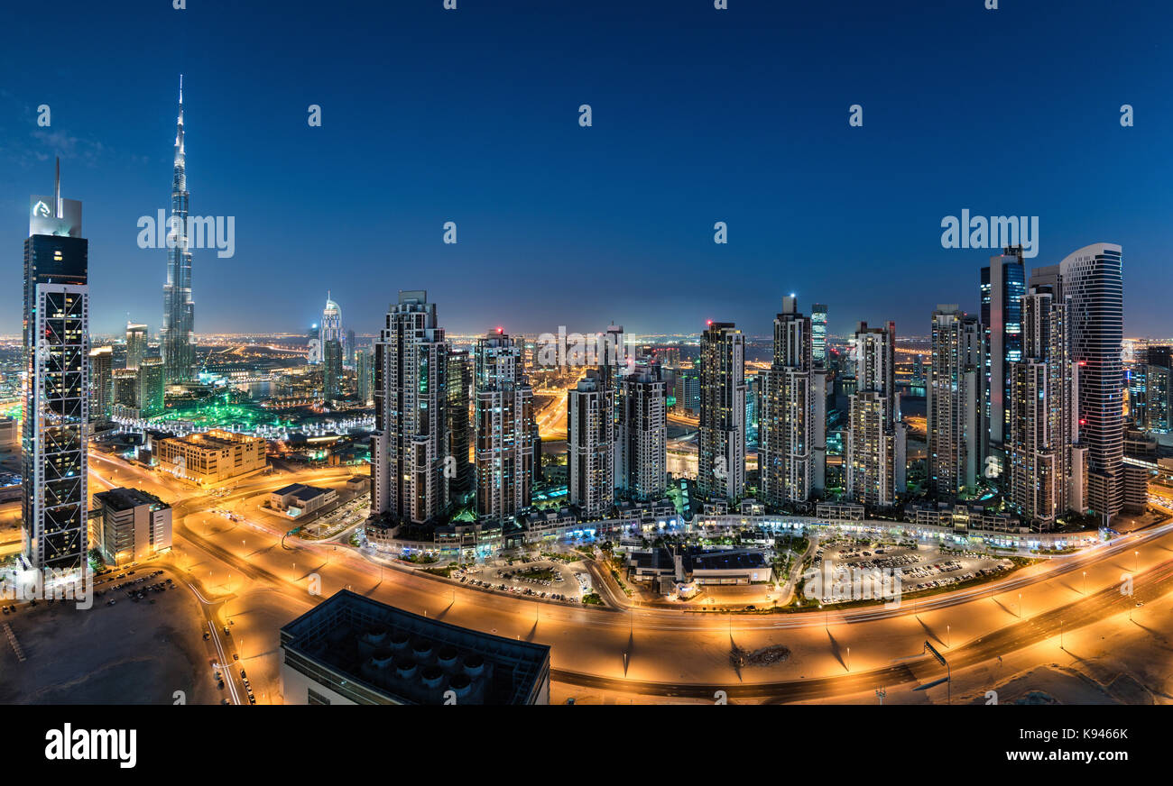 Das Stadtbild von Dubai, Vereinigte Arabische Emirate. bei Dämmerung, mit beleuchteten Wolkenkratzer im Vordergrund. Stockfoto