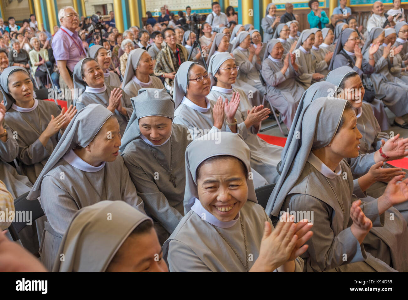 Chinesische katholische Nonnen applaudieren im Rahmen einer Zeremonie in der Kirche Xishiku in Peking, China. 21-Sep-2017 Stockfoto