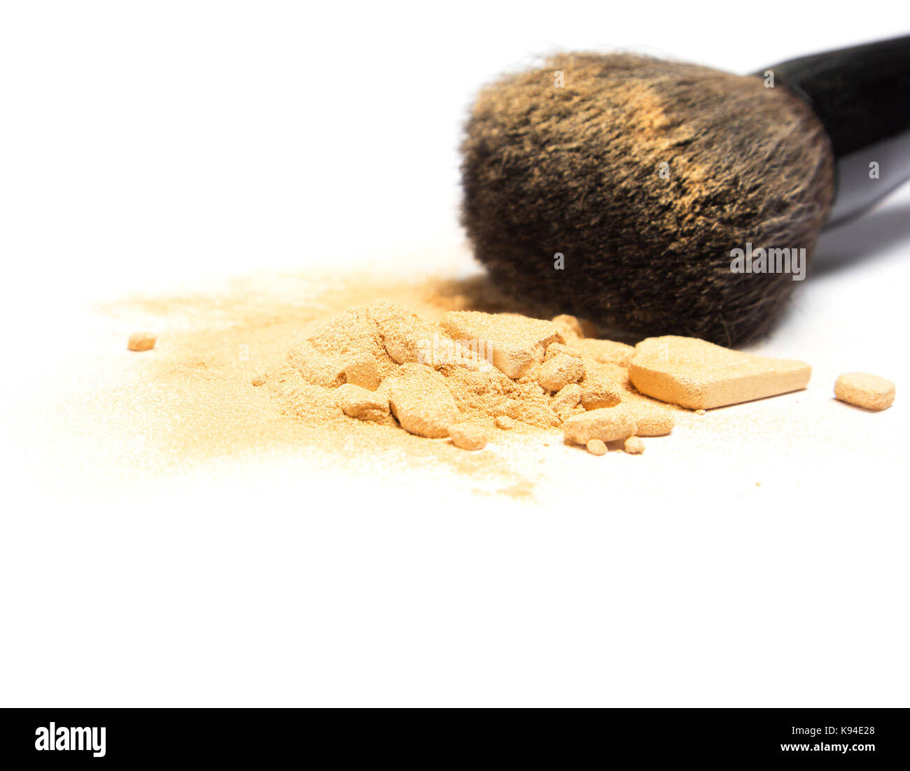 Close-up crushed Mineral shimmer Powder goldene Farbe mit Make-up-Pinsel auf weißem Hintergrund. Flache Tiefenschärfe Stockfoto