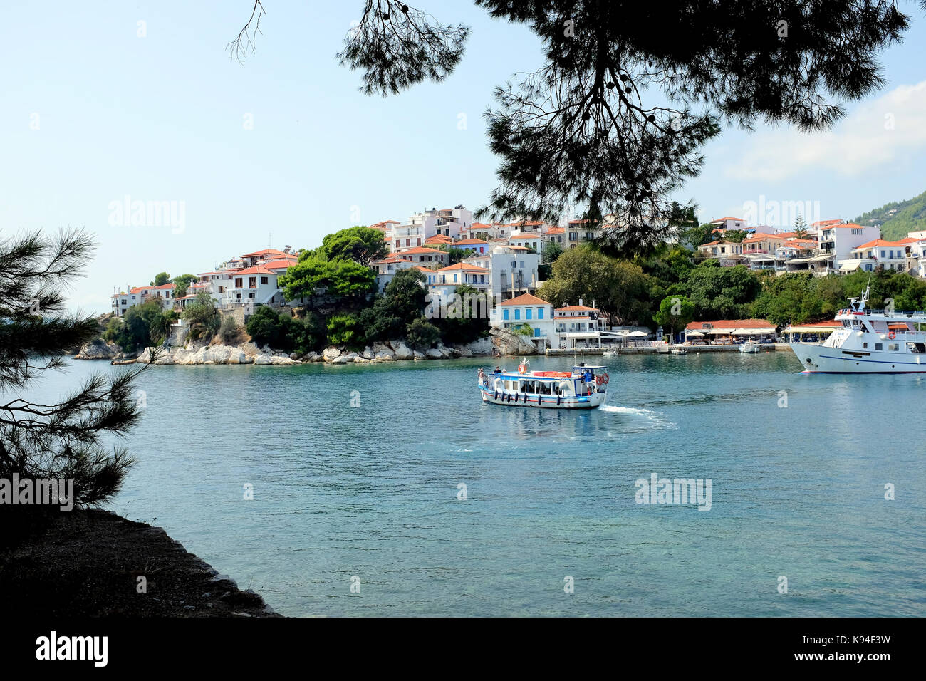Skiathos, Griechenland. September 10, 2107. Eine lokale Fähre Wassertaxi stellt weg vom alten Hafen mit dem Plakes Teil der Stadt im Hintergrund. Stockfoto