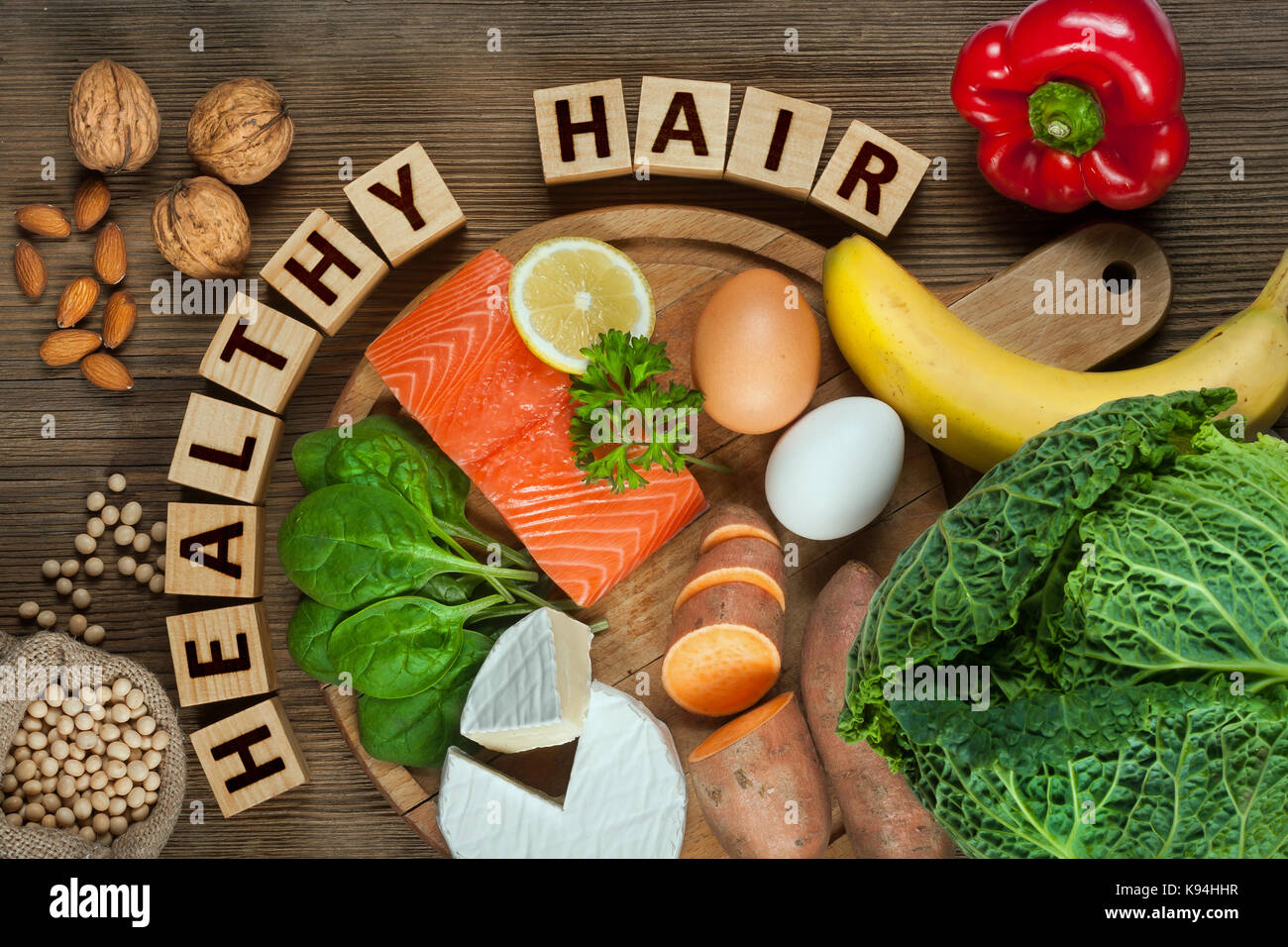 Gesundes Haar Konzept. Besten Lebensmittel für gesundes Haar wie Lachs, Spinat, Mandeln, süsse Kartoffeln, Eier, Nüsse, Kohl, Käse, Paprika, Bananen- und Stockfoto