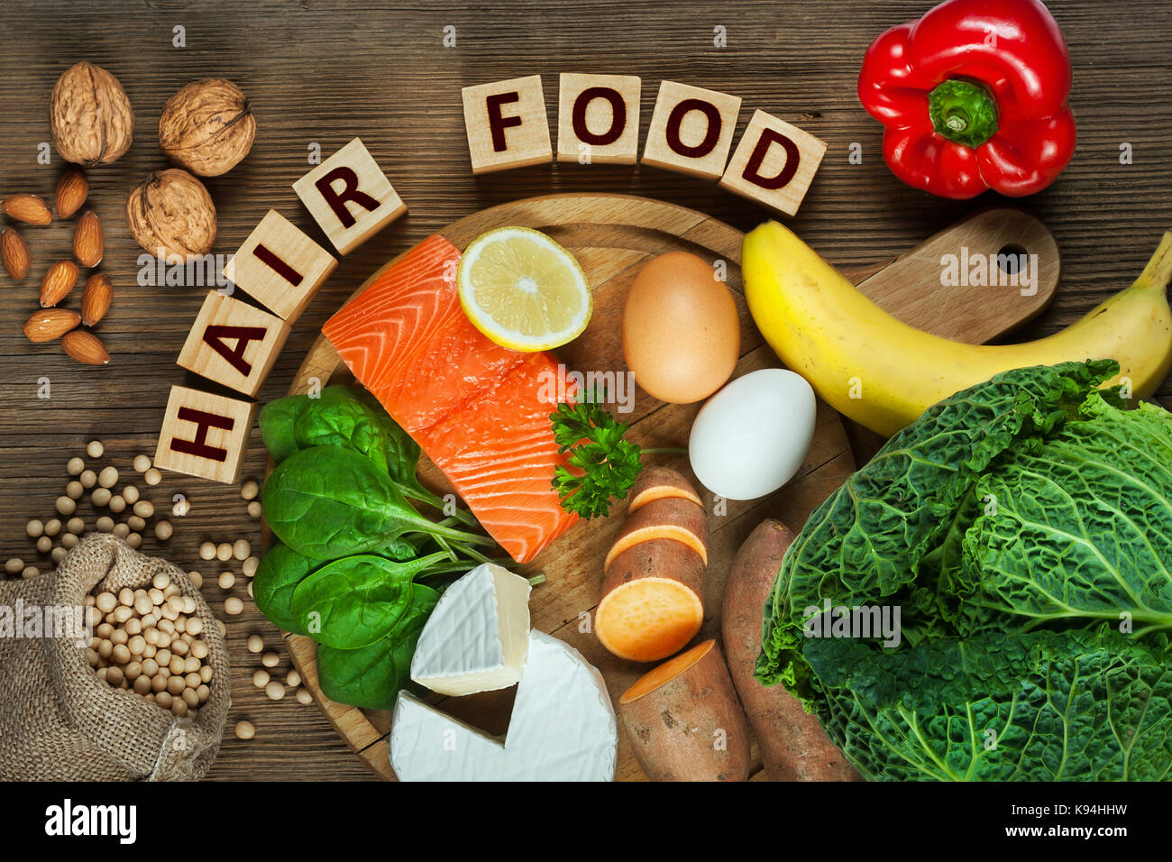 Gesundes Haar Konzept. Besten Lebensmittel für gesundes Haar wie Lachs, Spinat, Mandeln, süsse Kartoffeln, Eier, Nüsse, Kohl, Käse, Paprika, Bananen- und Stockfoto