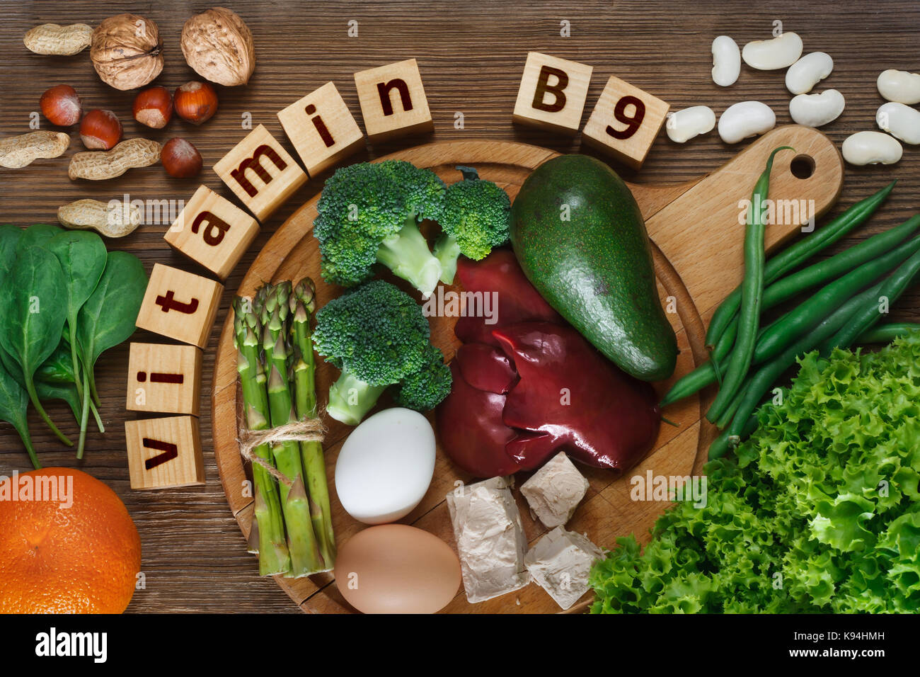 Lebensmittel, die reich an Vitamin B9 (Folsäure) wie Leber, Spargel, Brokkoli, Eier, Salat, Avocado, Hefe, Nüssen, Spinat, Orange und Bohnen. Ansicht von oben Stockfoto
