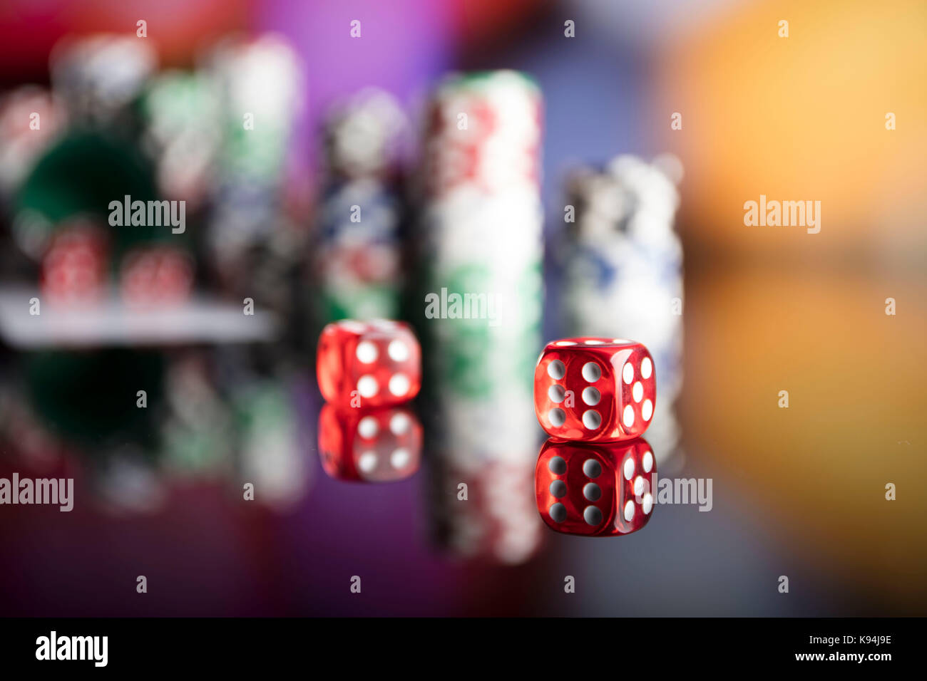 Casino Thema. Kontrastreiches Bild von casino Roulette, Poker Spiel, Würfelspiel, poker chips auf einem Spieltisch, alle auf bunten bokeh Hintergrund. Stockfoto