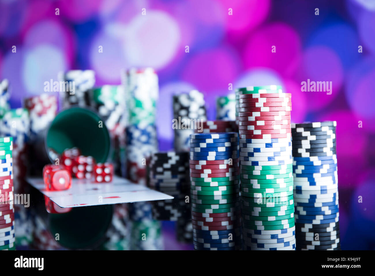 Casino Thema. Kontrastreiches Bild von casino Roulette, Poker Spiel, Würfelspiel, poker chips auf einem Spieltisch, alle auf bunten bokeh Hintergrund. Stockfoto