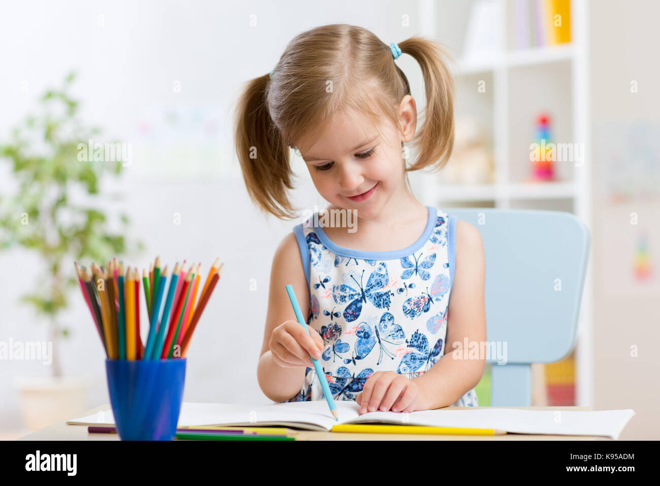 Kind Mädchen zeichnen mit bunten Stiften in Kindergarten Stockfoto