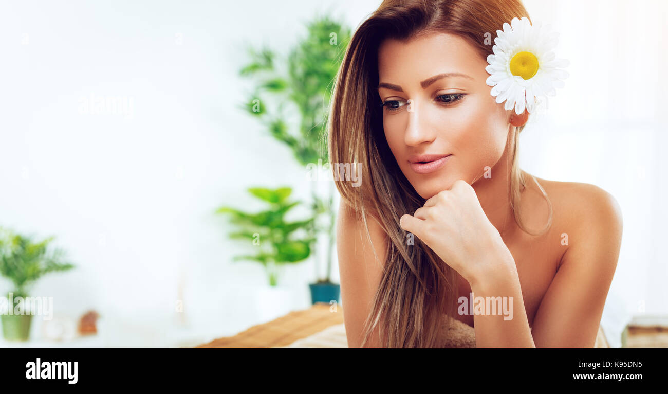 Junge schöne nachdenkliche Frau genießen Sie während einer skincare Behandlung in einem Spa. Stockfoto