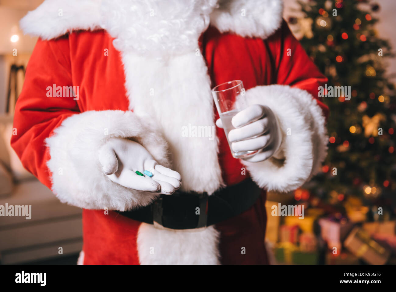 Santa Claus mit Glas Wasser und Pillen Stockfoto