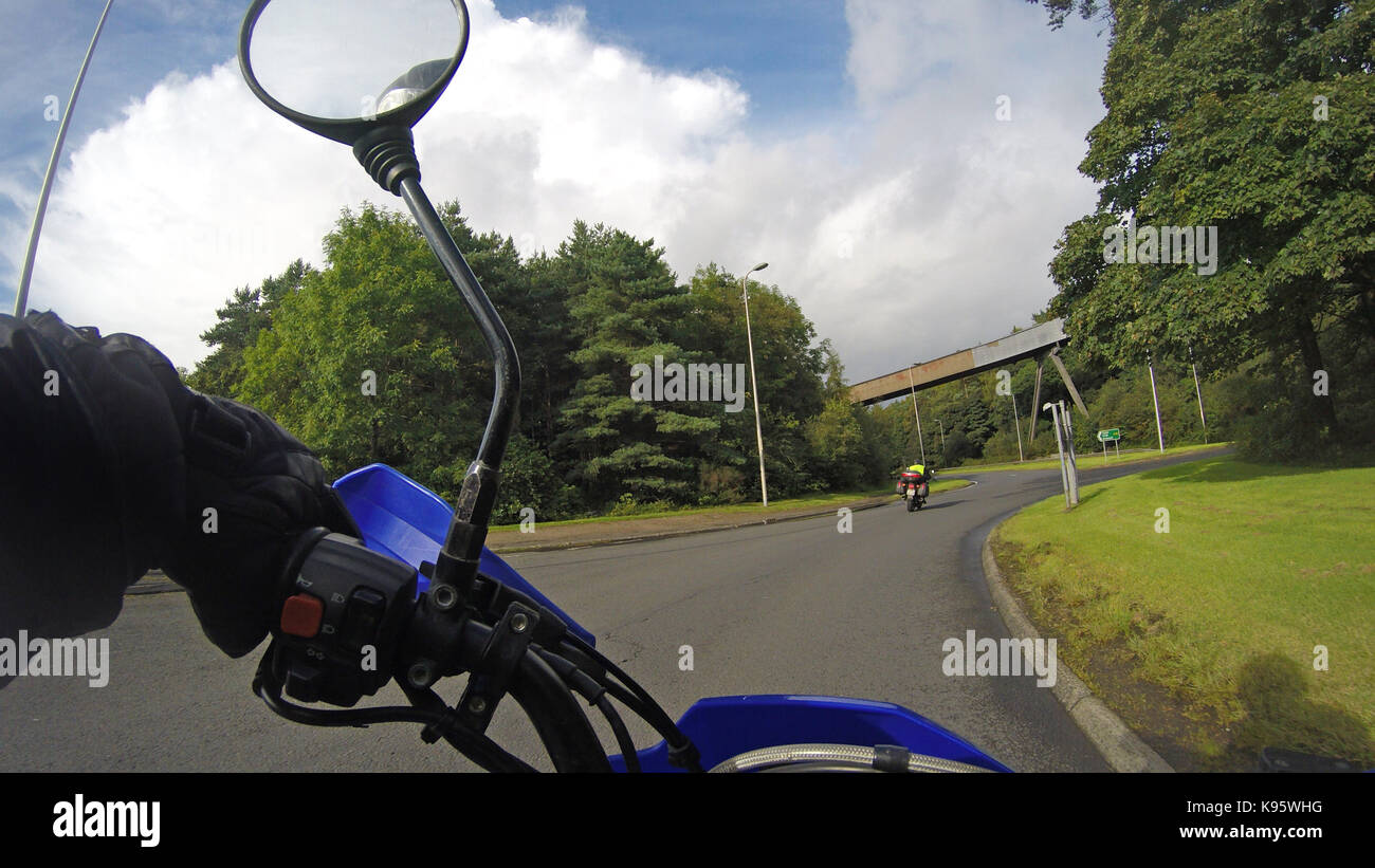 GoPro Blick von einem Motorrad als Reiten entlang einer britischen Land  Straße an einem sonnigen Tag. Sie können sehen, ein Arm, Lenker und  Rückspiegel Stockfotografie - Alamy