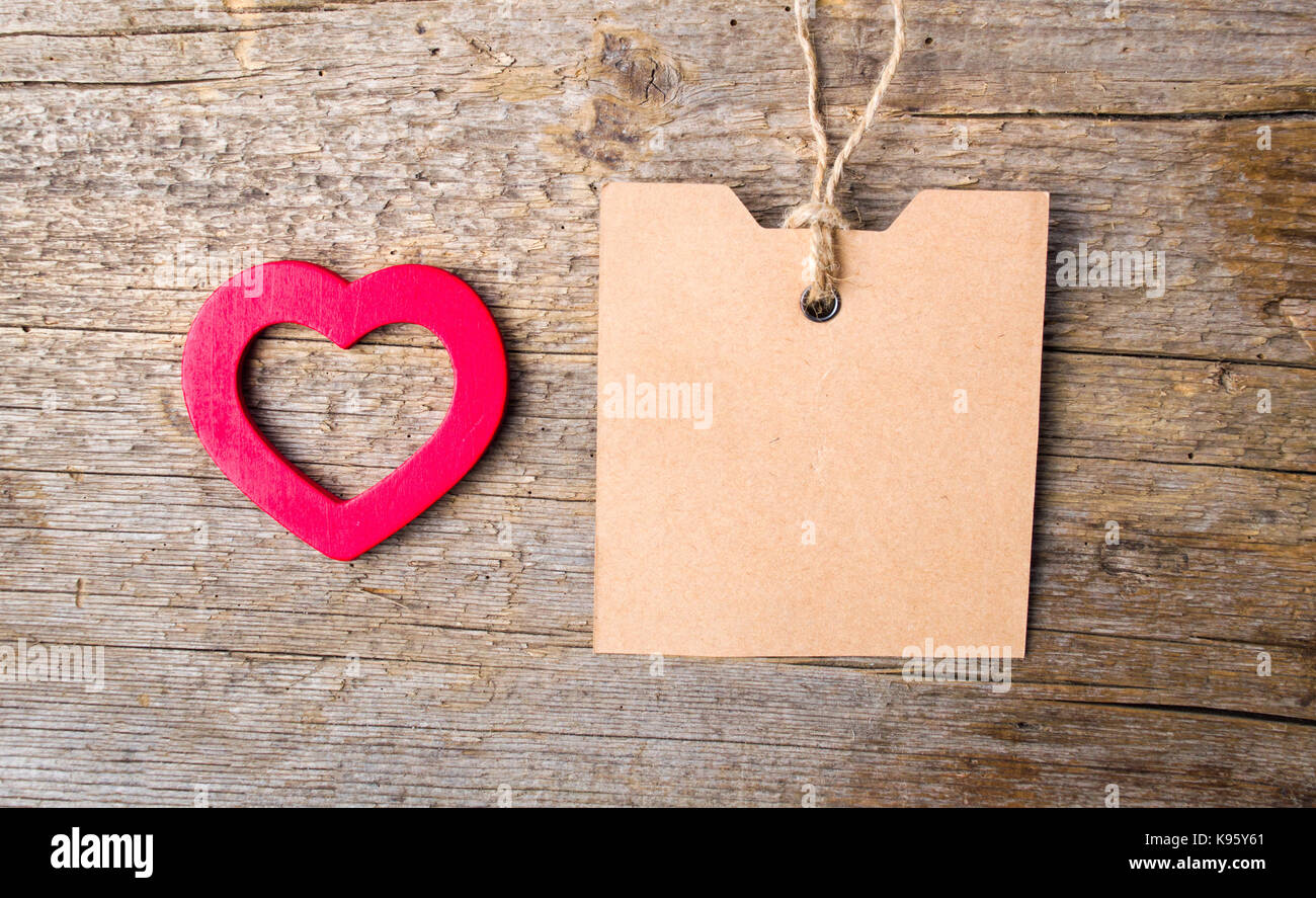 Herz Form und Leere Karte auf einem rustikalen Holzmöbeln Hintergrund Stockfoto