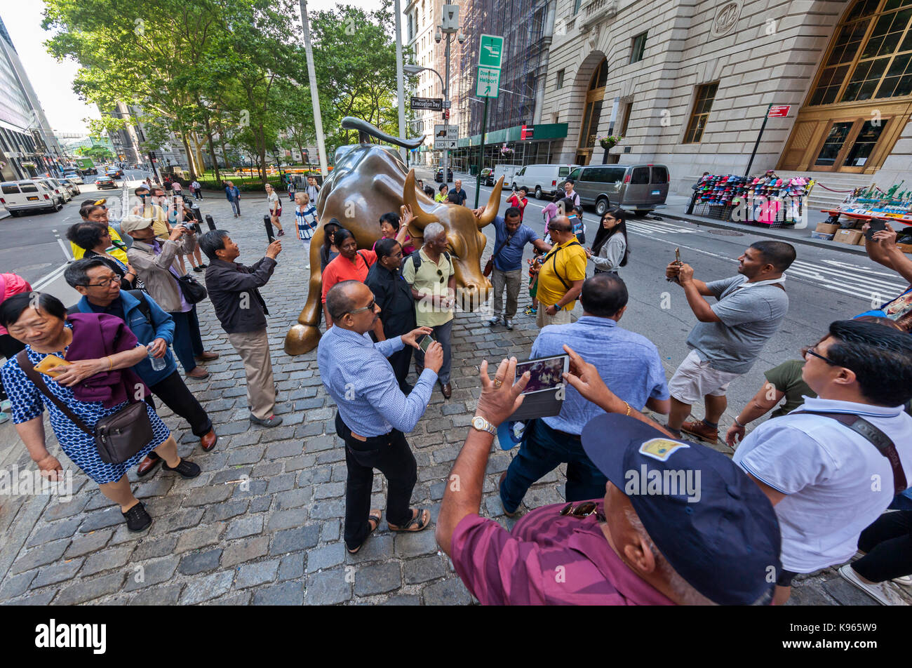 Die wütenden Stier Statue und der furchtlose Mädchen Statue von Touristen im Finanzdistrikt umgeben, in der Nähe der New Yorker Börse in Manhattan, Stockfoto