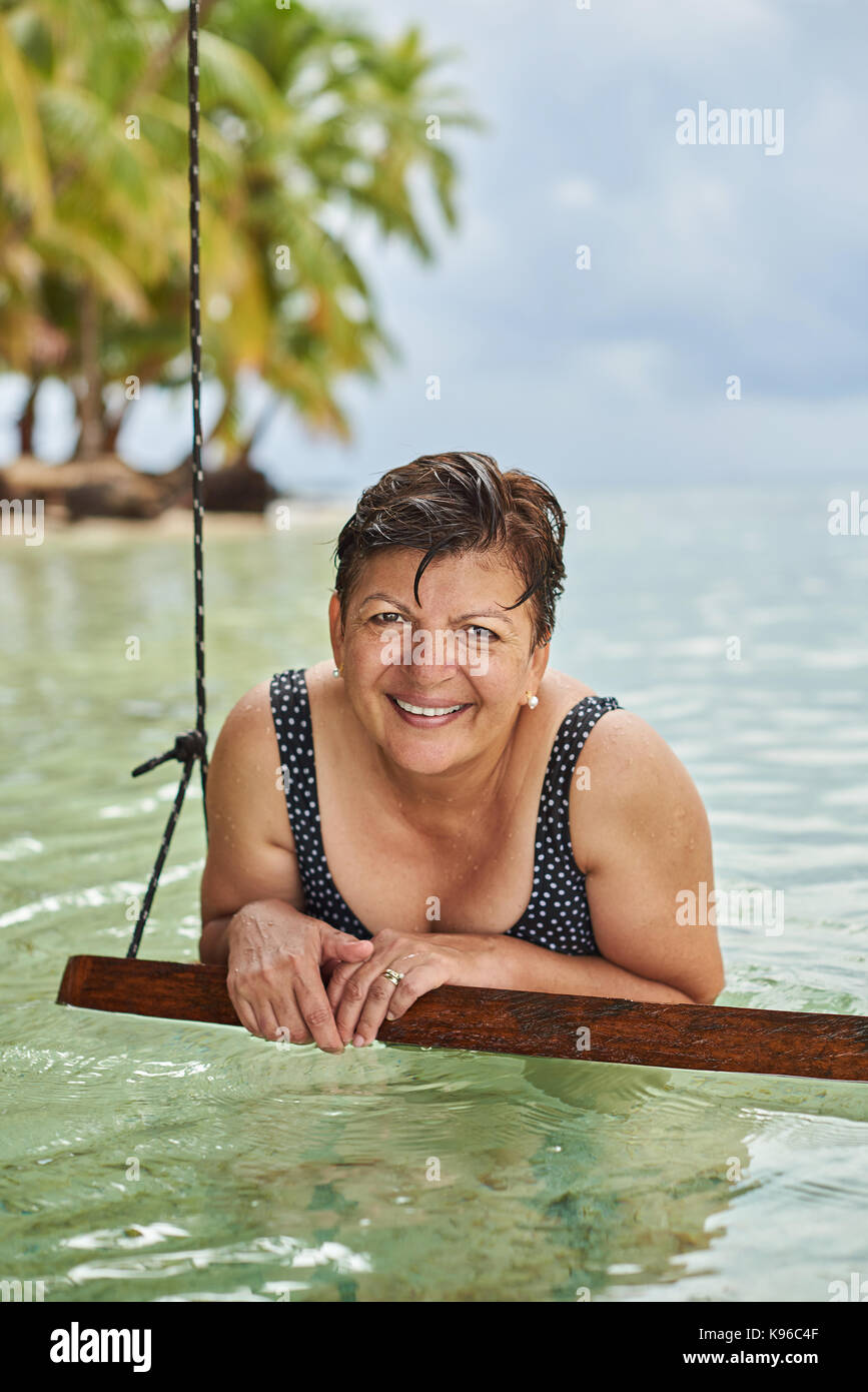 Ein Lächeln auf den Lippen reife Frau am Meer Strand Stockfoto