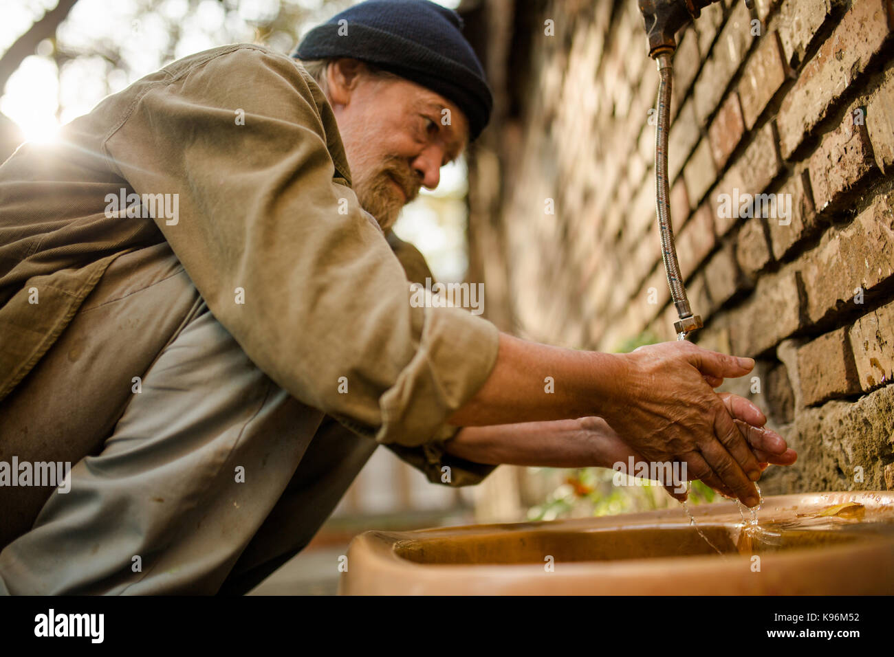 Nahaufnahme von Obdachlosen waschen Hand in der Straße. Stockfoto
