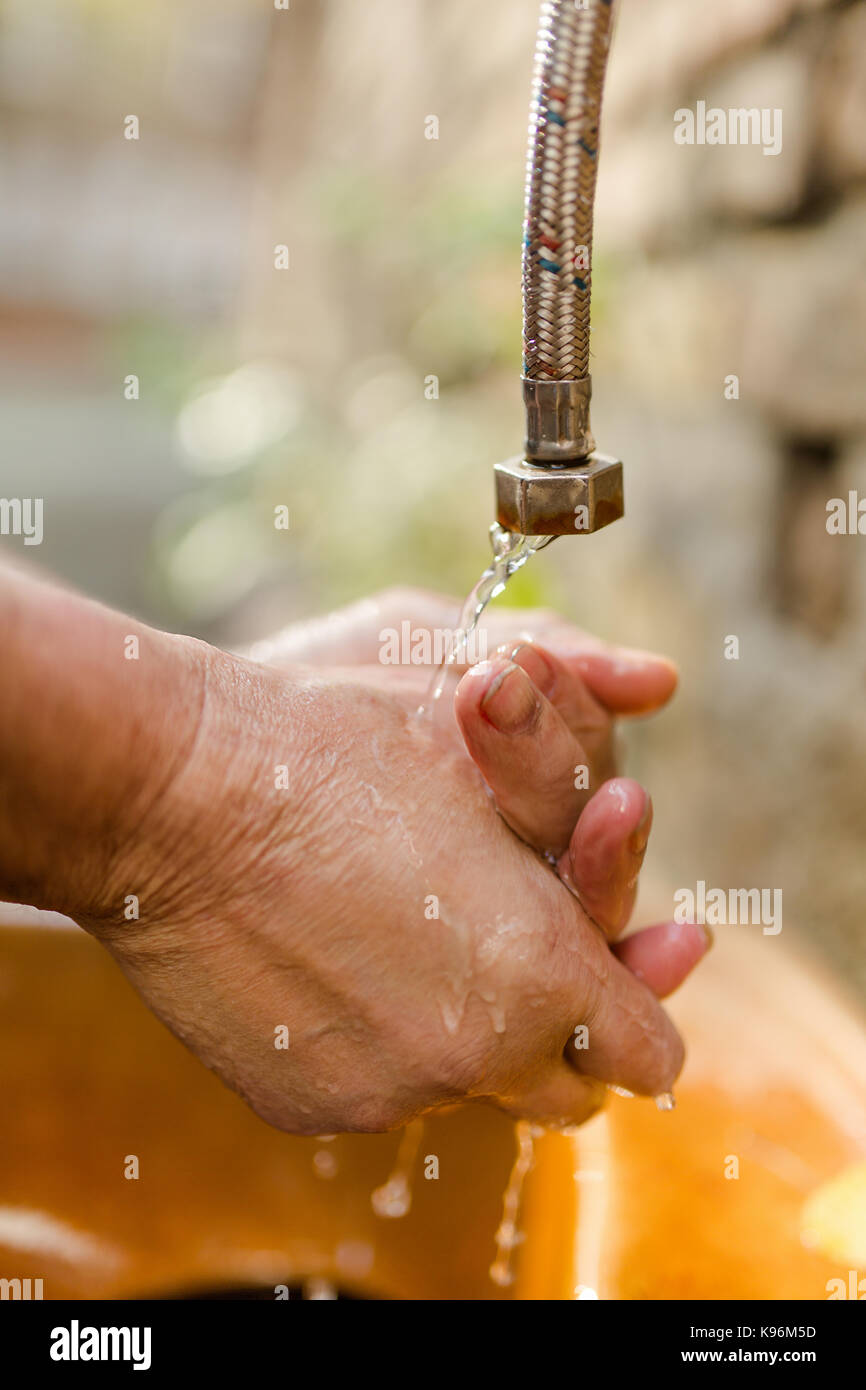 Nahaufnahme der Hände unter kaltes Wasser gewaschen werden. Stockfoto