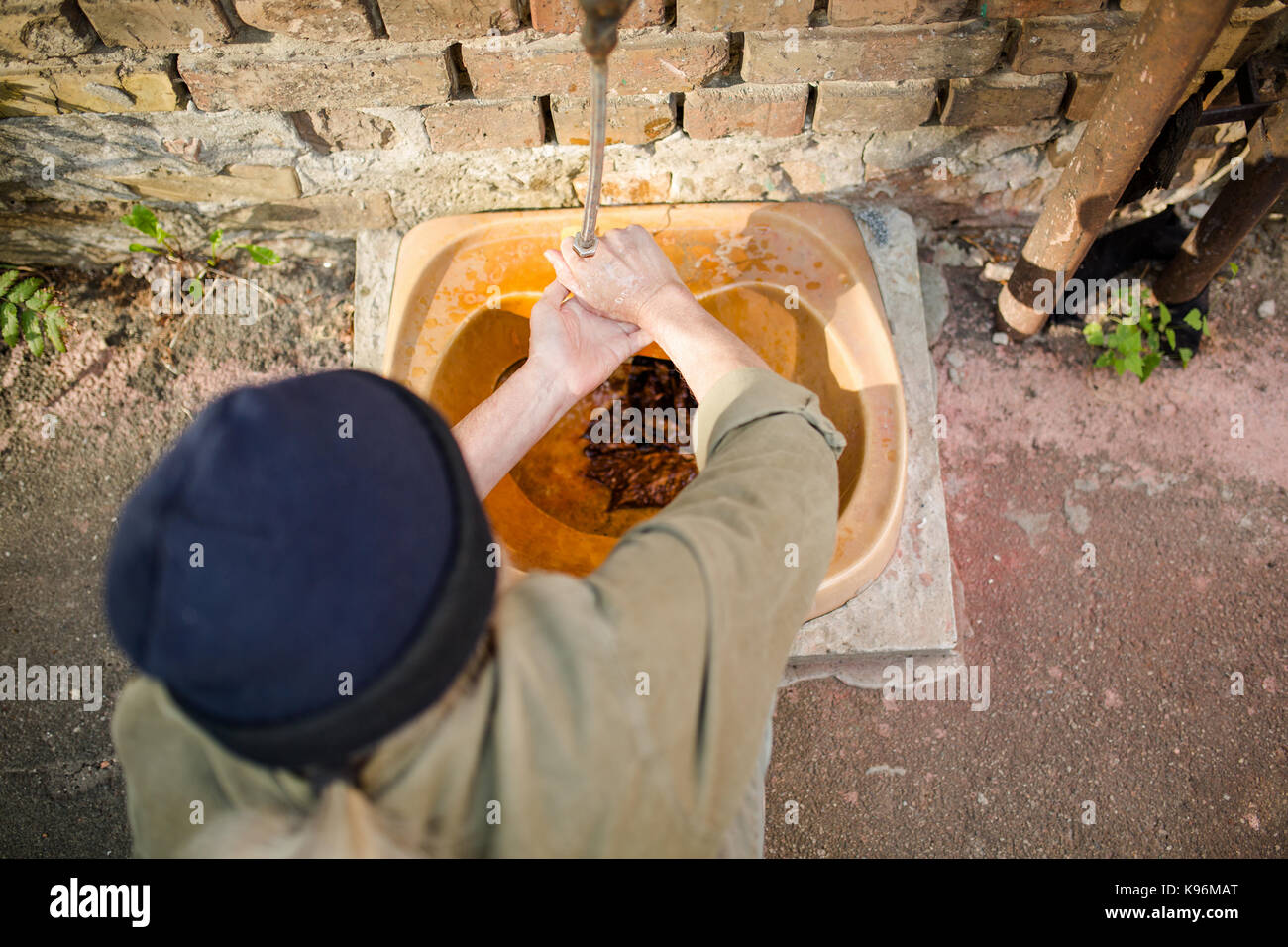 Blick von oben auf die Alten tramp Waschen der Hände in alten Spüle. Stockfoto