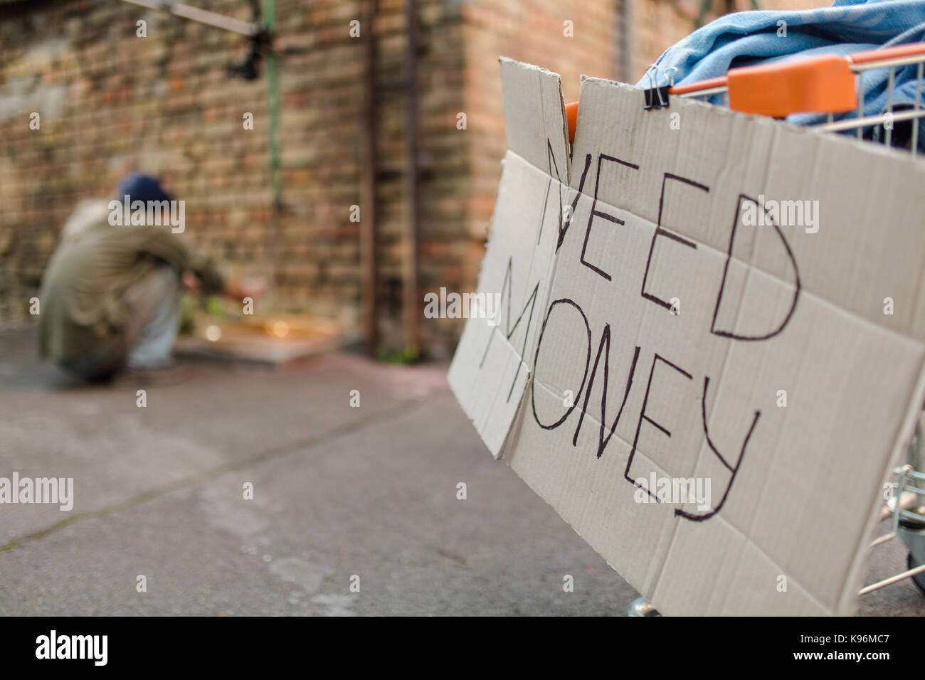 Zeichen auf Karton brauchen Geld, Obdachlosen Waschen der Hände auf der Bühne. Stockfoto