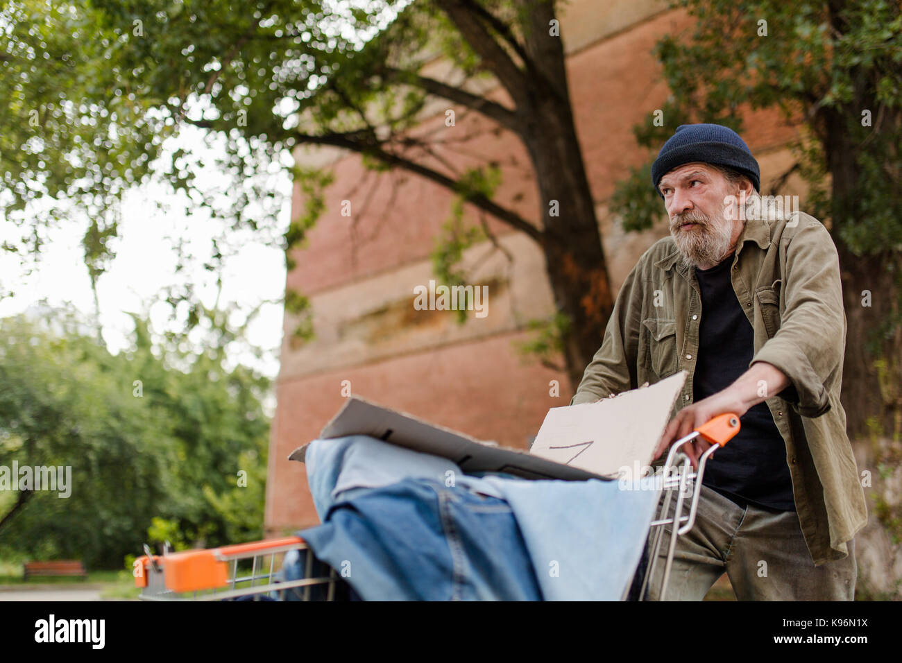 Anzeigen von Obdachlosen Mann drücken Warenkorb. Stockfoto