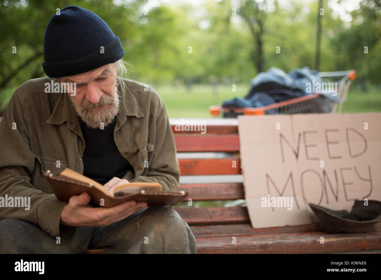 Alte bärtige Mann ohne Heimat, ein Buch zu lesen. Stockfoto